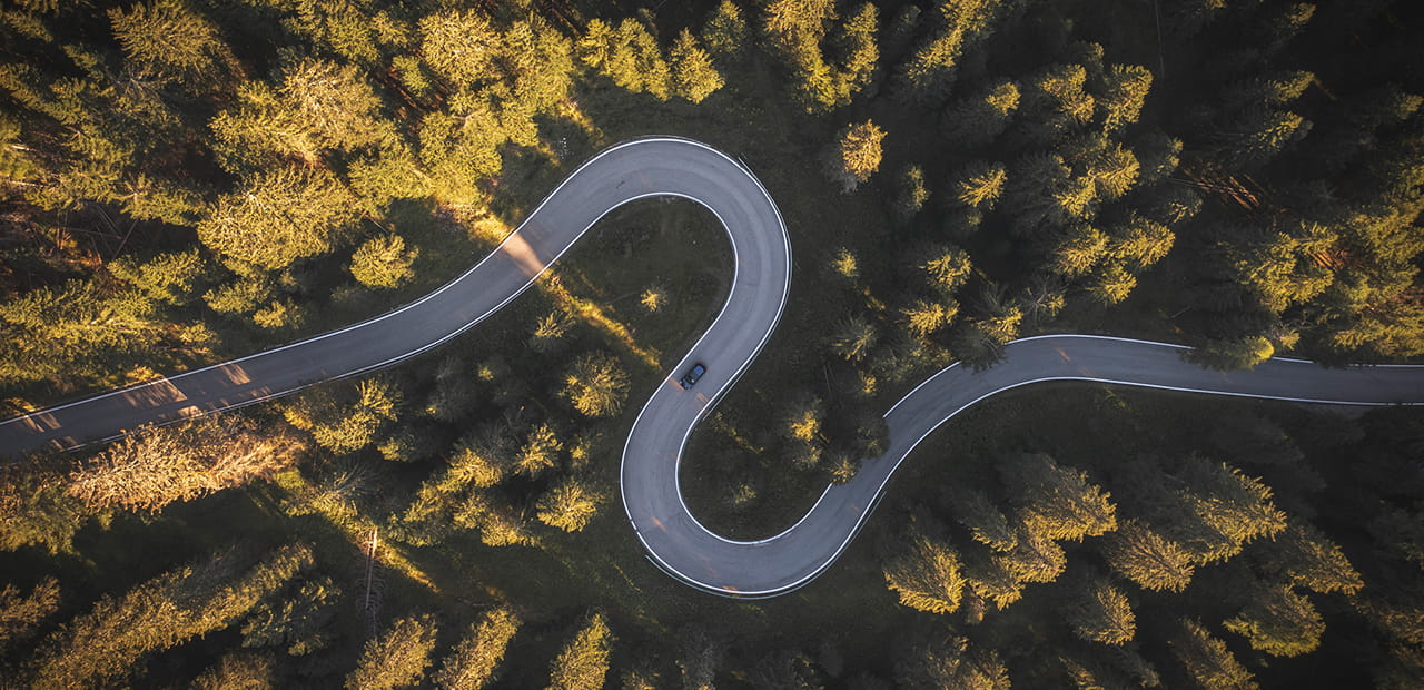Aerial view of a curving road, representing markets navigating periods of volatility and change.